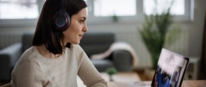 Woman in headphones attending an online course and making notes Woman in headphones attending an online course and making notes