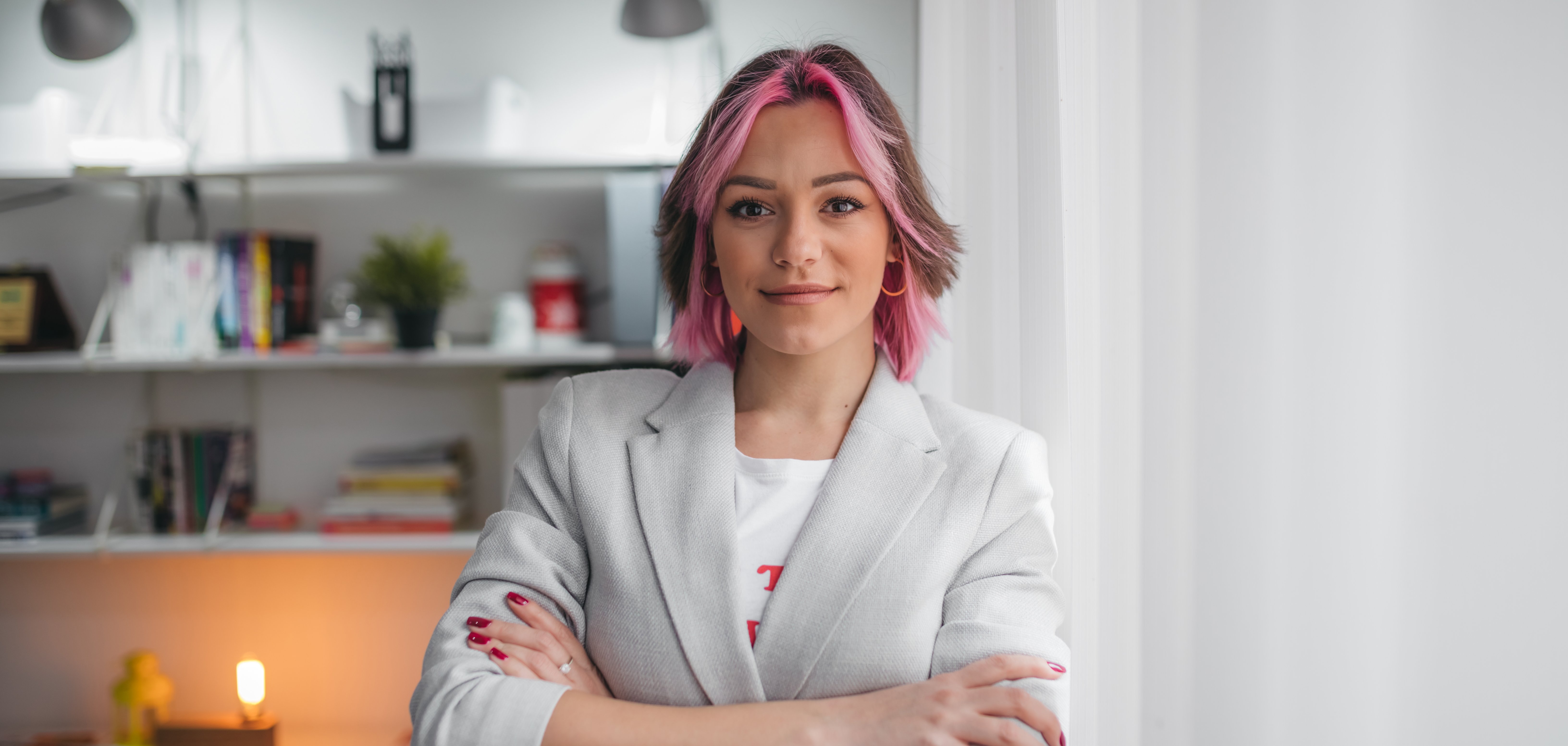 Smiling female professional manager standing arms crossed looking at camera