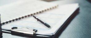 Shot of a notebook and pen on a desk in an office Shot of a notebook and pen on a desk in an office